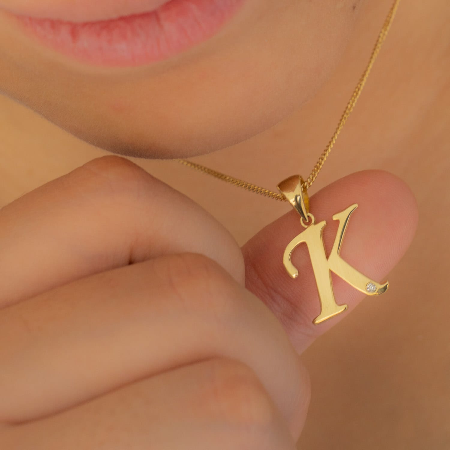 Dije letra y diamante